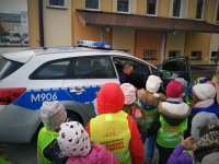 Policjant opowiada dzieciom o elementach wyposażenia radiowozu.